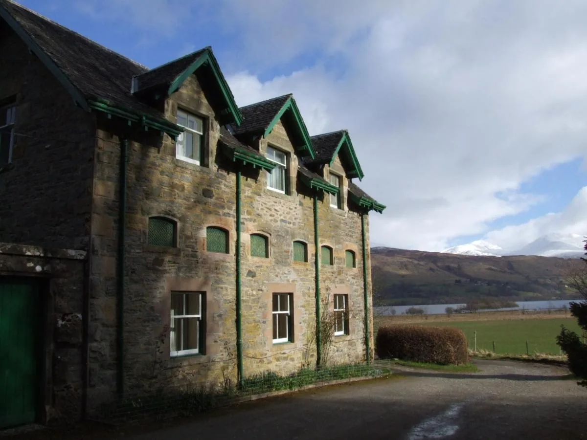 The stone courtyard building at Auchmore with its green painted dormers, looking towards the hills above Loch Tay