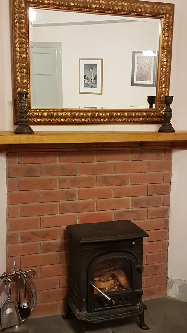 Woodburning stove in the cosy games and TV room of the Lawers Apartment